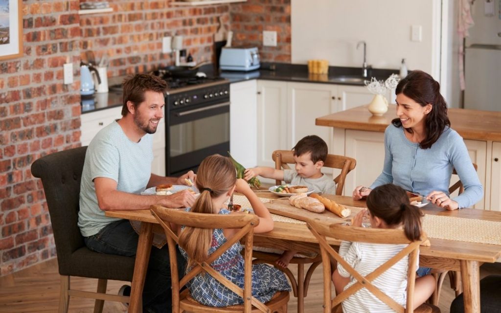 A family sits together for a meal at a dining room table.