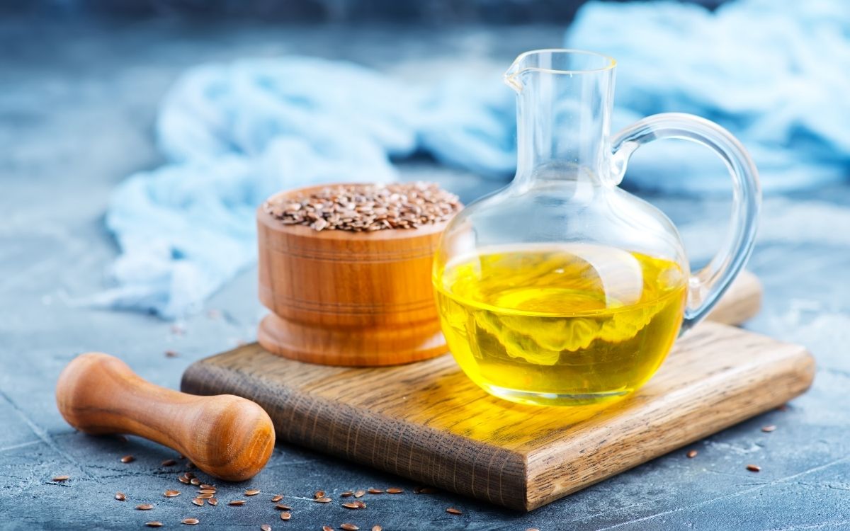 Seed oil sits next to a bowl of seeds.