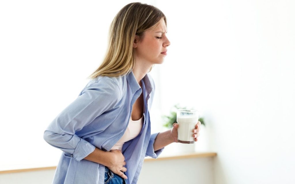Women seems to have an upset stomach while drinking milk. 