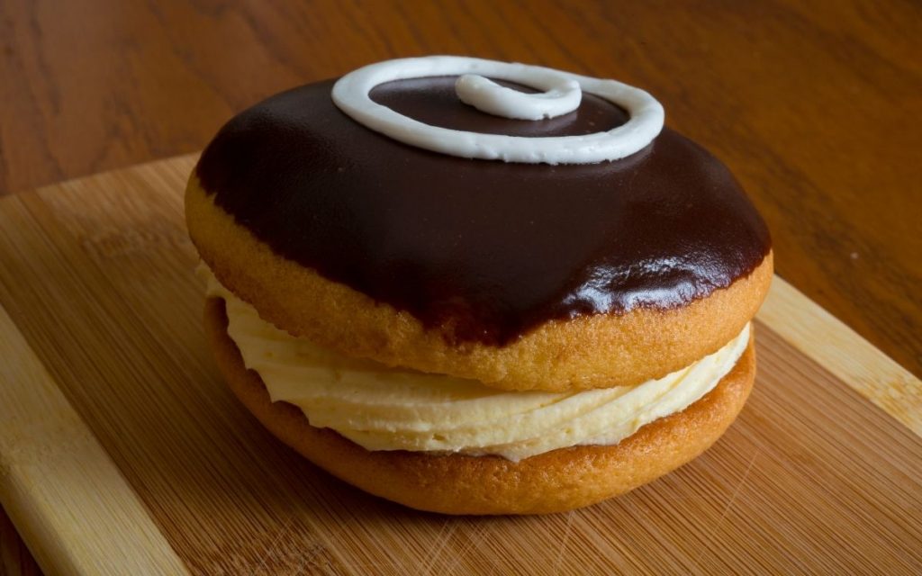 A boston cream pie sits on a table.