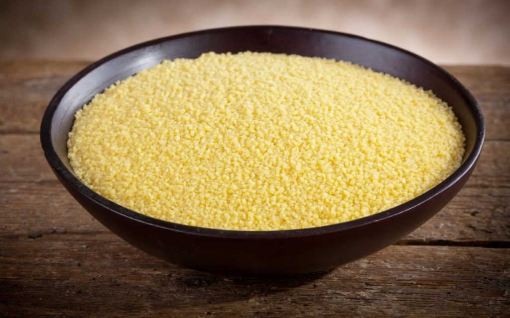 A bowl of couscous sits on a table.