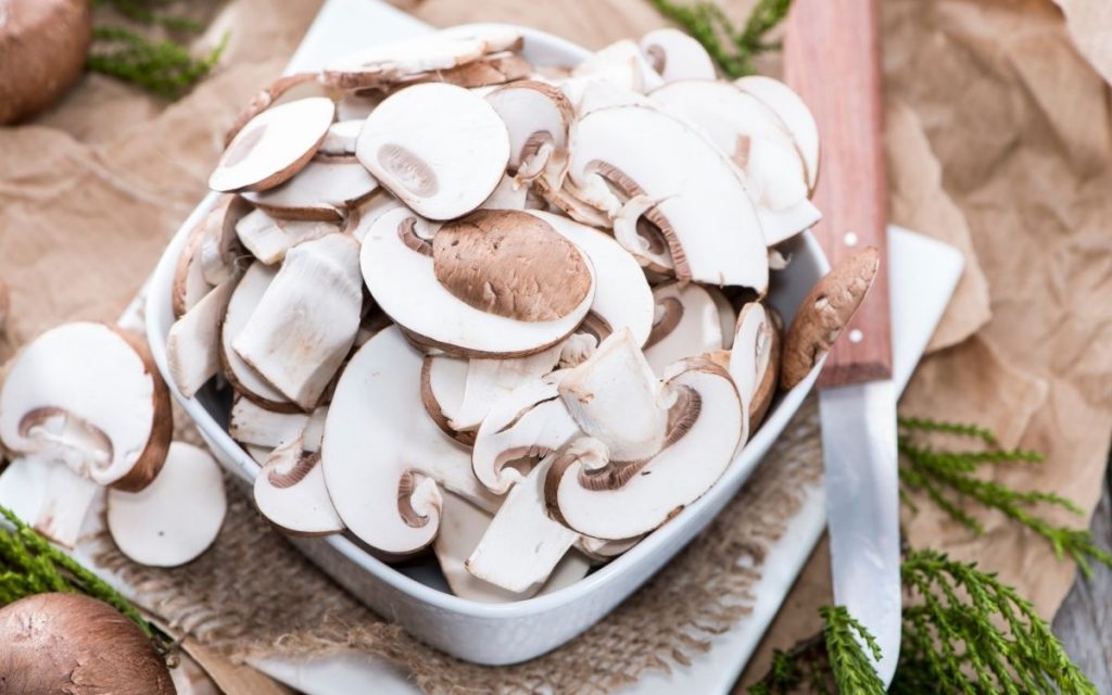 Bowl of freshly sliced mushrooms.
