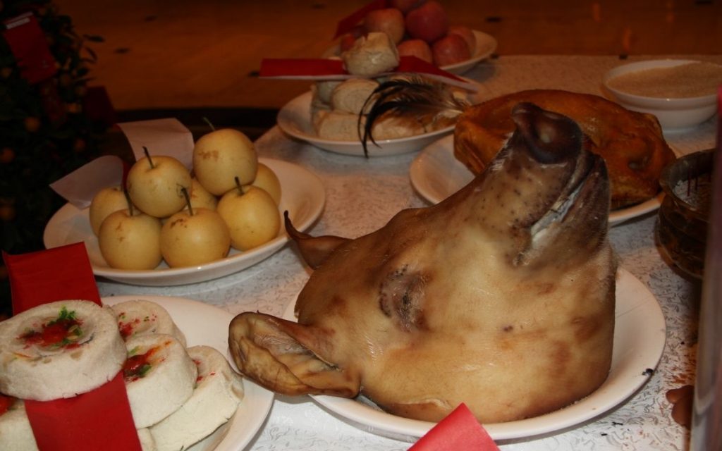 A pig head sits on a plate net to various choices.