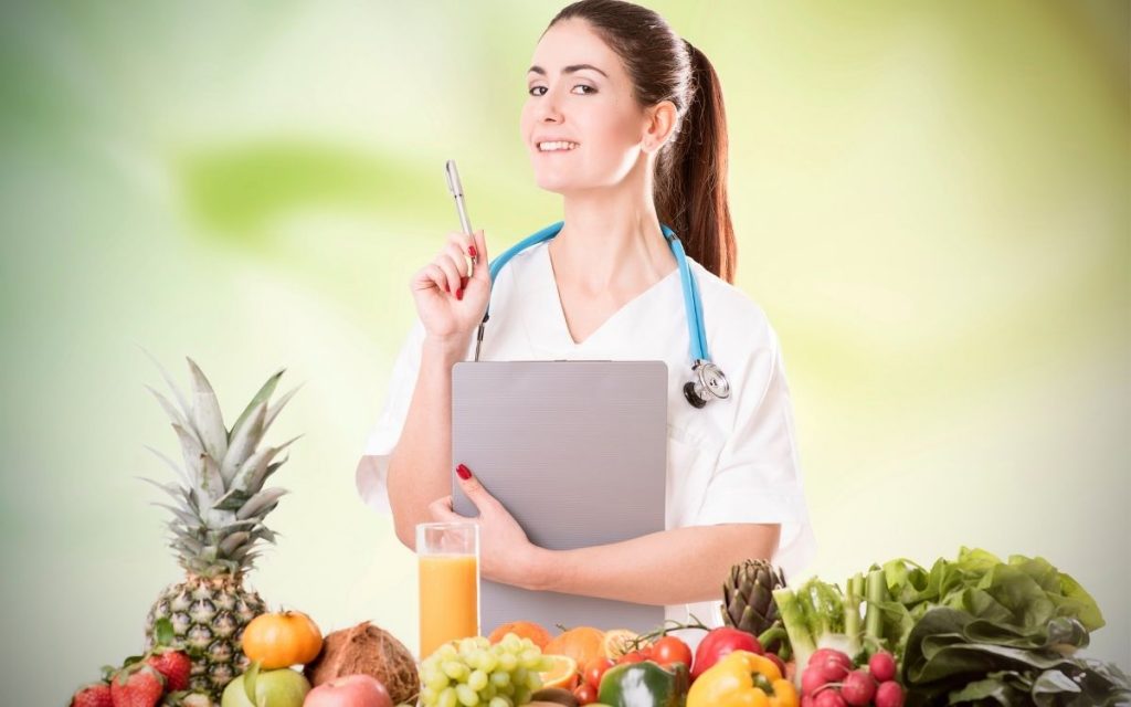Dietitian in front of fruits and vegetables.