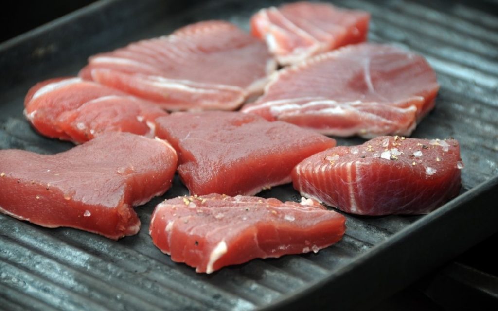 Fresh tuna steaks on a grill.