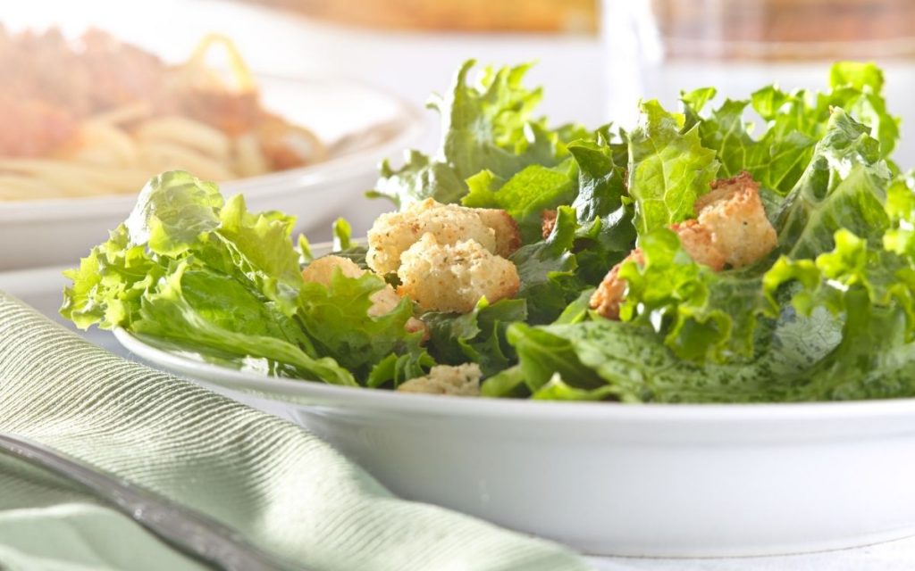 A bowl of salad with leafy greens.