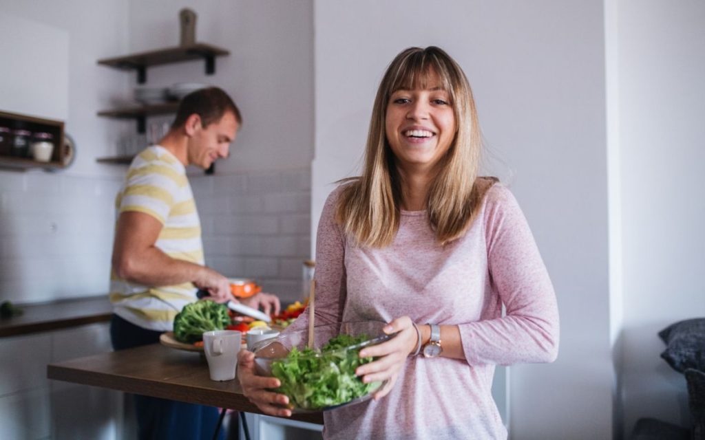 Happy vegan couple cooking together.