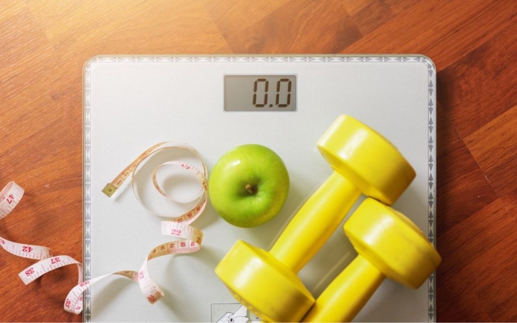 Apple and weights sit on scale.